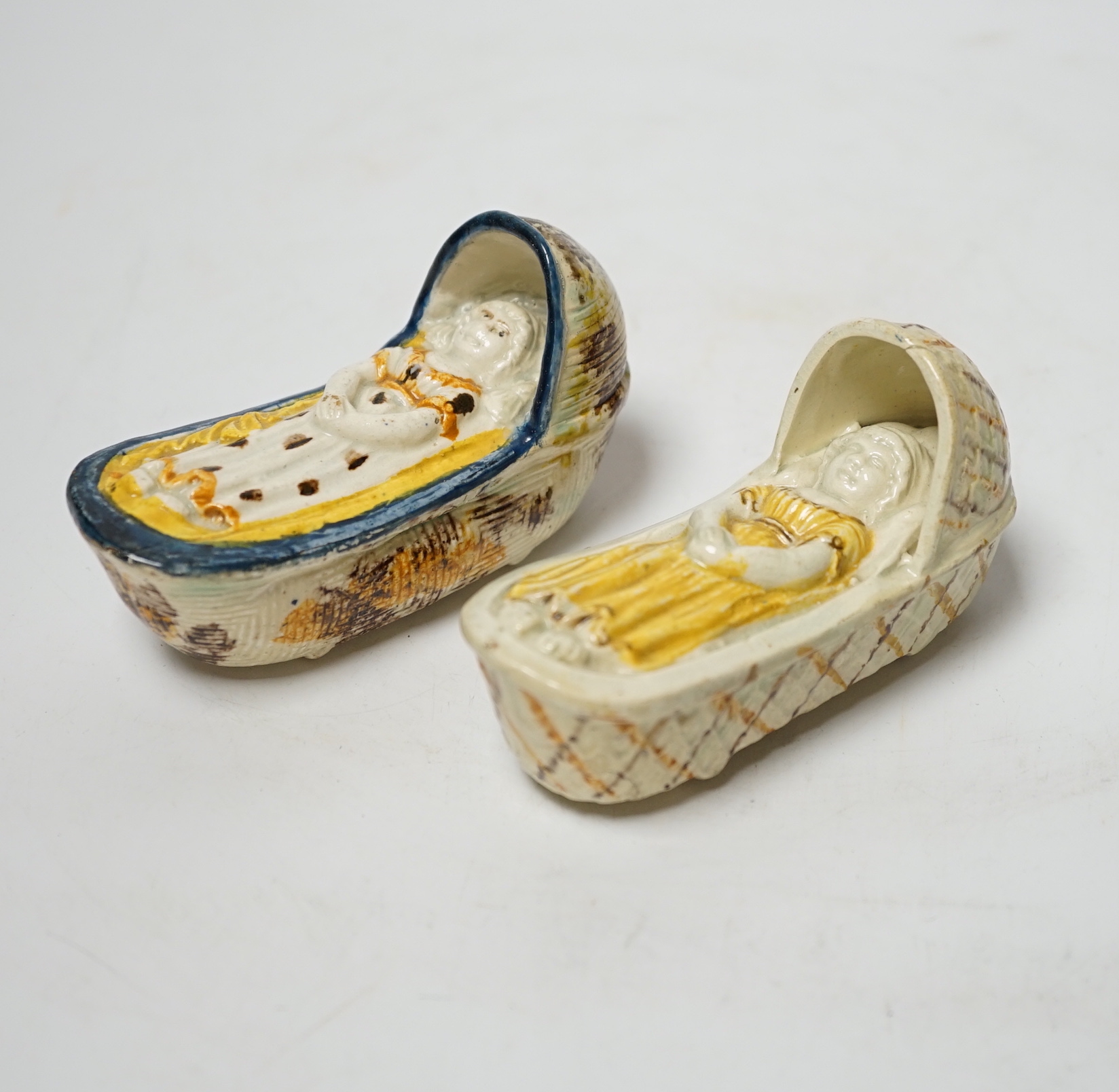 Two late 18th century Prattware ‘crib’ models of cradles, 10cm long